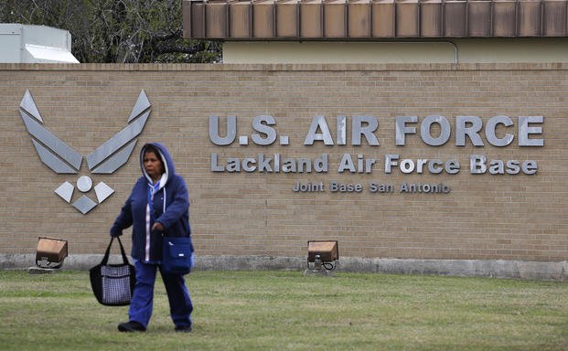 A pedestrian passes the main gate at Lackland Air Force Base in San Antonio.