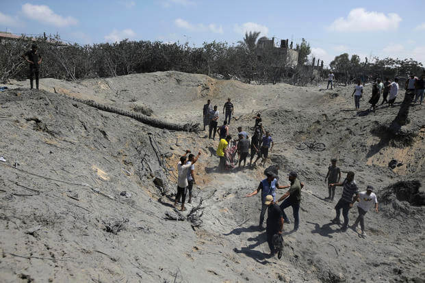 Palestinians search for bodies and survivors in a site hit by an Israeli bombardment on Khan Younis