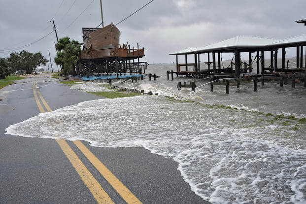 Storm surge breaks over a sea wall in Horseshoe Beach, Fla.