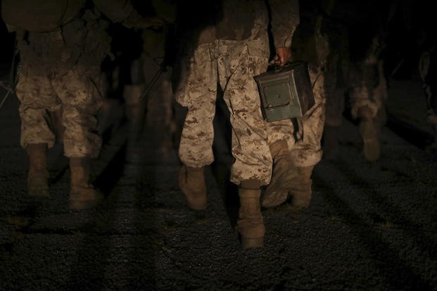 Recruits with Alpha Company, 1st Recruit Training Battalion, hike with ammo cans during a night movement and supply event during the Crucible aboard Marine Corps Depot Parris Island.