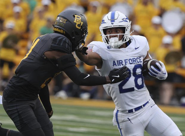 Air Force running back Aiden Calvert stiff-arms Baylor linebacker Keaton Thomas