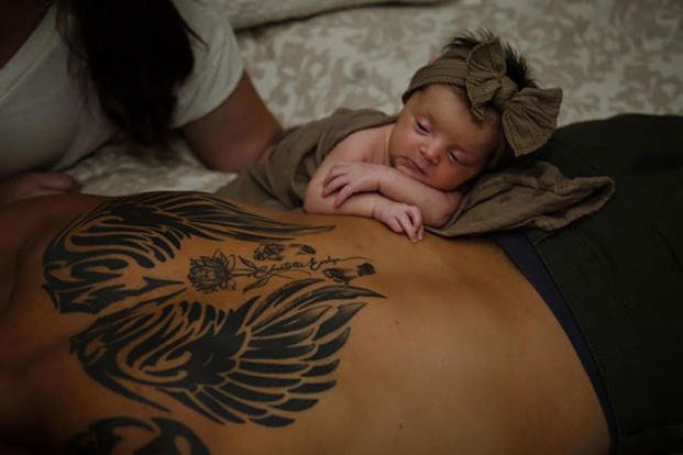 Gracie rests with mom and dad near the tattoo on her father’s back of angel wings, a rose and Charlotte Evelyn’s footprints. 