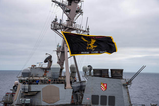 The Arleigh-Burke class guided missile destroyer USS Curtis Wilbur (DDG 54) steams near the aircraft carrier USS Nimitz (CVN 68) in the Pacific Ocean. 