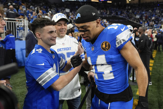 Jacob Rinehart shakes hands with Detroit Lions wide receiver Amon-Ra St. Brown 