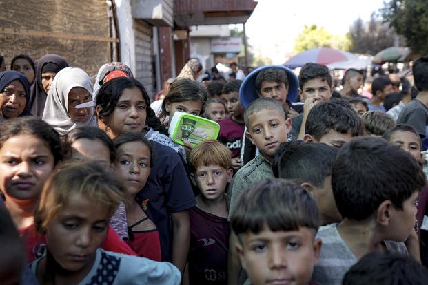 Palestinians line up for food in Deir al-Balah, Gaza Strip