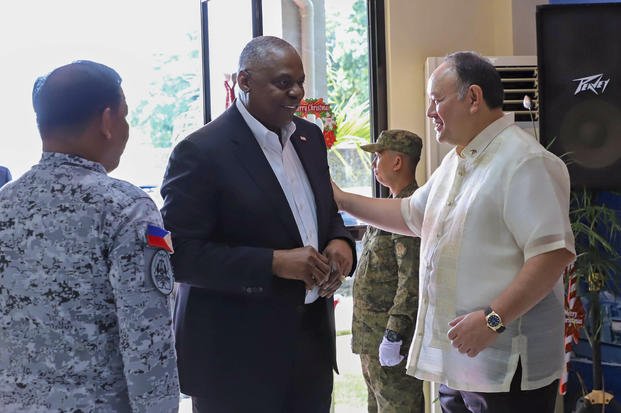 Philippine Defense Secretary Gilberto Teodoro, right, greets United States Defense Secretary Lloyd Austin