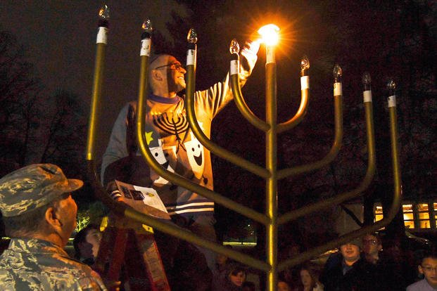 Howard Worona lights the menorah as members of the Hanscom Air Force Base community in Massachusetts gather.