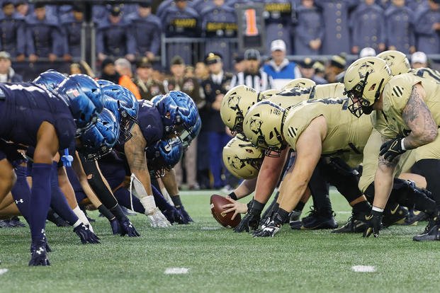 The Navy Midshipmen and the Army Black Knights line up for the snap at the line of scrimmage during the first quarter of an NCAA football game at Gillette Stadium