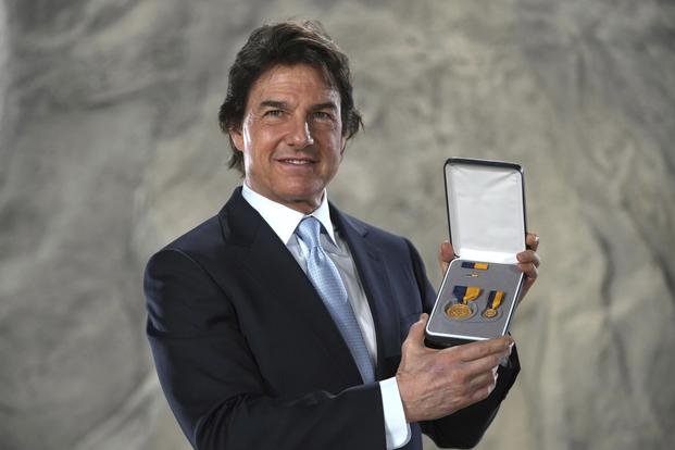 Tom Cruise poses with the Navy Distinguished Public Service Award 