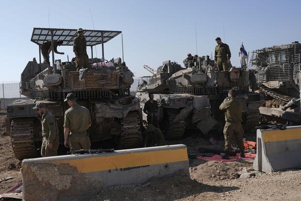 Israeli soldiers work in a staging area on the Israel-Gaza border.