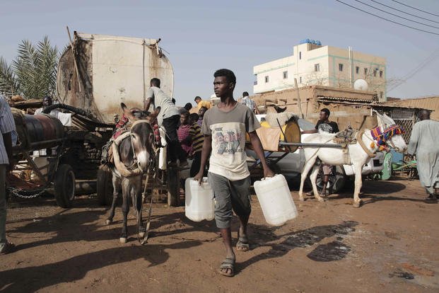 People gather to collect water in Khartoum, Sudan.