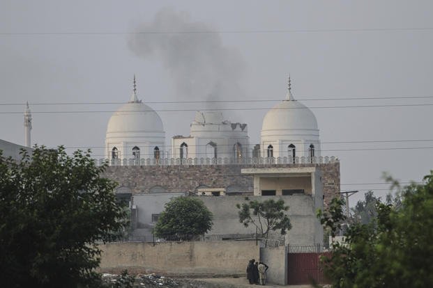 Local residents stand outside a mosque of an Islamic seminary partially damaged by a suspected Indian missile attack, outskirts of Bahawalpur, Pakistan