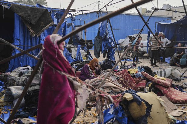 Palestinians inspect the damage caused by an Israeli airstrike.