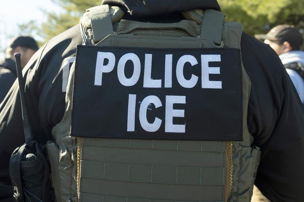 A U.S. Immigration and Customs Enforcement officer listens during a briefing