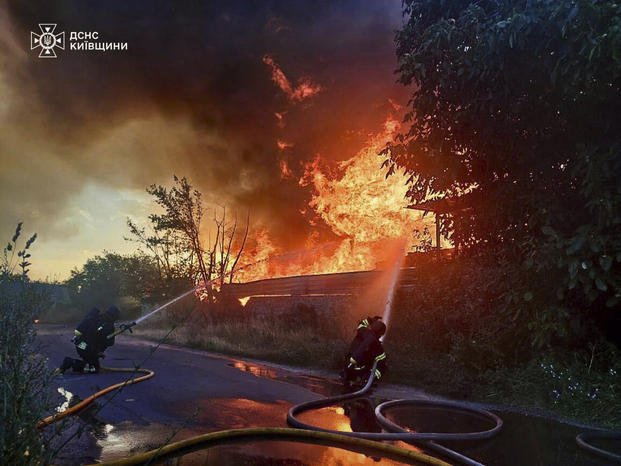 In this photo provided by the Ukrainian Emergency Service, firefighters put out the fire following a Russian attack in Kyiv region