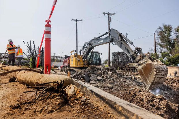 Contractors hired by the U.S. Army Corps of Engineers clean up a property damaged by wildfire in Pacific Palisades, California.