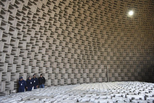 U.S. Coast Guardsmen walk with a member of NASA around the Aeroacoustic Propulsion Laboratory dome during a tour at NASA Glenn Research Center, Cleveland.