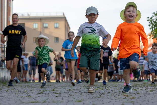 Kids run along a road in Italy. 