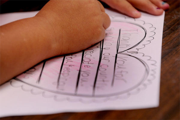 child writing card for service member