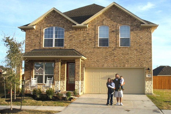 Family standing in front of a new home.