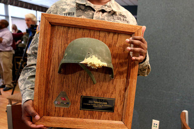 Army Staff Sgt. Thalamus Lewis received the helmet that saved his life in Afghanistan at an April 19 ceremony at Fort Belvoir, Va. The enemy rifle round struck the right side of his Advanced Combat Helmet and blew out the front. Matthew Cox/Military.com