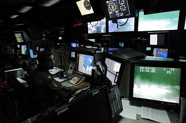 An officer stands watch in a carrier's combat direction center