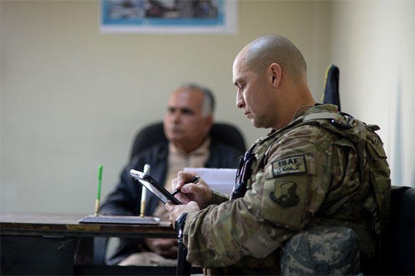   Senior Master Sgt. Carmelo Vega Martinez takes notes during a meeting with Afghan Air Force recruiters, Feb. 25, 2014, Kabul, Afghanistan.