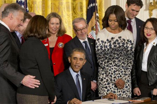 Richard Selke and Susan Selke, left, the parents of Clay Hunt, smile at President Obama as he signs the Clay Hunt Suicide Prevention for American Veterans Act, Thursday, Feb. 12, 2015. (AP Photo/J. Scott Applewhite)