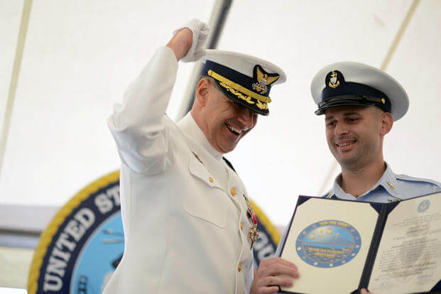 Capt. Greg Stump (left), cheers with one fist in the air as he is inducted as an honorary chief during a change of command ceremony in San Francisco, Tuesday July 19, 2016. (Photo: Petty Officer 3rd Class Adam Stanton)