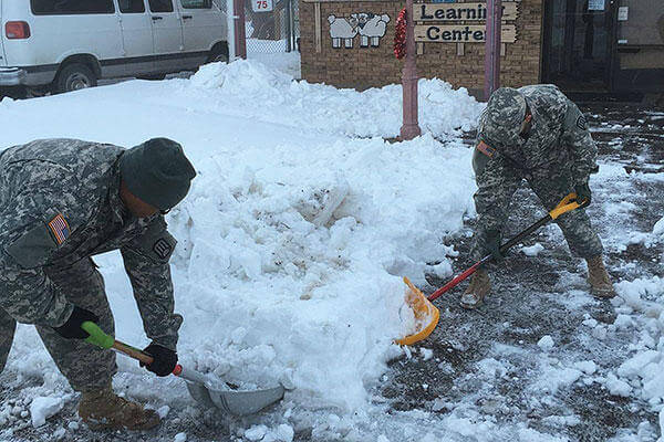 Soldiers remove snow from a walkway in front of Little Lambs Chapter II Daycare Center in Roswell, N.M. (Courtesy photo)