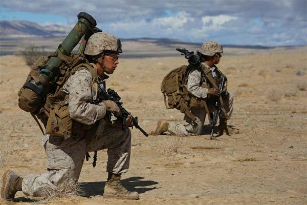 Two sergeants take cover while maneuvering to conduct an enemy counter attack during a pilot test at Range 107, Marine Corps Air Ground Combat Center Twentynine Palms, California, March 2, 2015. (Photo by Sgt. Alicia R. Leaders)