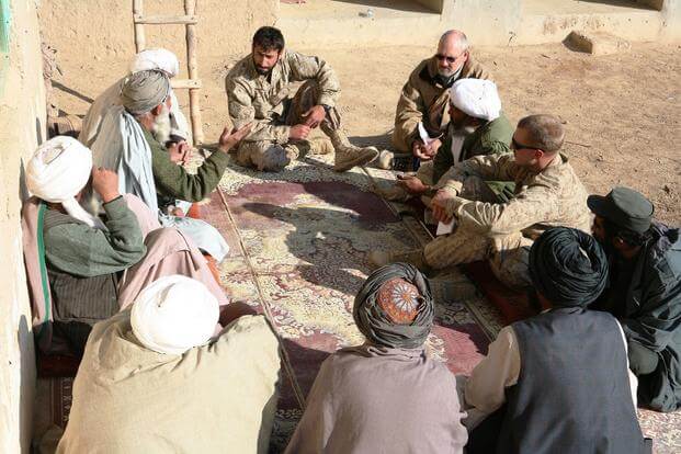 Capt. Jason C. Brezler, right, the team leader for 3rd Battalion, 4th Marine Regiment's civil affairs group, speaks with local elders in Now Zad, Afghanistan, Dec. 15, 2009. (Marine Corps Photo/Zachary Nola)