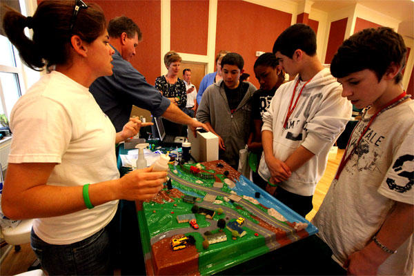 Alicia Filzen of Camp Lejeune's Environmental Management Division shows students how contaminants, trash and oils can seep into nearby lakes and rivers, during the Marine Corps base's Earth Day Expo on April 18, 2011. (Marine Corps photo/Victor Barrera)