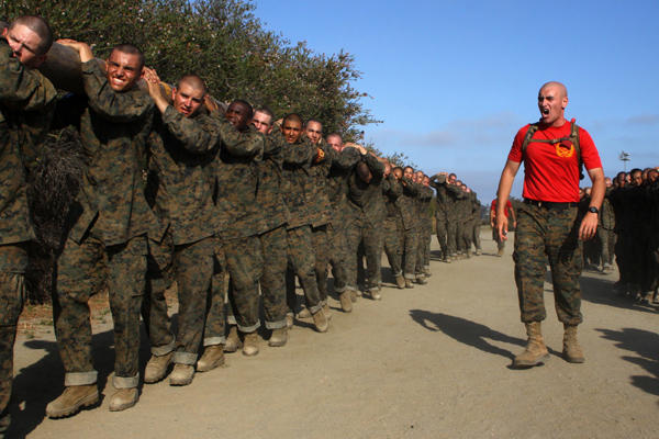 Marine recruits carrying a log