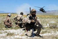 Air Force pararescuemen and a simulated “survivor” watch as an HH-60G Pave Hawk helicopter lands.