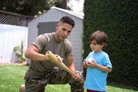 Soldier and son playing baseball