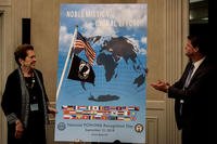 The 2018 National POW/MIA Recognition Day poster is revealed during the Annual National League of Families meeting in Crystal City, Virginia on June 21. The poster was unveiled by Ann Mills- Griffiths, Chairman of the Board and CEO of the National League of POW/MIA Families, left, and Randall G. Schriver, Assistant Secretary of Defense for Asian and Pacific Security. (US Marine Corps photo/Lauren Gramley)