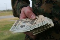 A hand holding a wad of cash. (U.S. Marine Corps photo by Sgt. Alicia R. Leaders)