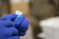 A nurse readies a flu shot. (. (U.S. Army National Guard/Erica Knight)