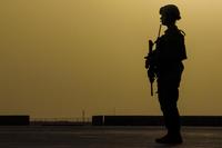 Airman scans an airfield for potential threats at Camp Shorabak, Afghanistan, formerly Camp Bastion, while a C-130J Super Hercules from the 774th Expeditionary Airlift Squadron transfers equipment and personnel March 16, 2016. (U.S. Air Force/Tech. Sgt. Robert Cloys)