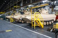 A line of M113A3/BMP-2 Opposing Forces Surrogate Vehicles await the final production step – assembly of their doors – in Anniston Army Depot’s Combat Vehicle Repair Facility. (U.S. Army photo/Mark Cleghorn)