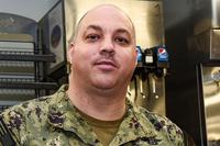 Command Master Chief Jonas Carter poses for a photo after donating to the Navy and Marine Corps Relief Society during a fundraiser kickoff aboard the Nimitz-class aircraft carrier USS Harry S. Truman. (U.S. Navy/Mass Communication Specialist 3rd Class Joseph A.D. Phillips/Released)