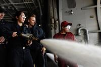 Sailors operate a fire hose while spraying Aqueous Film Forming Foam off the hangar bay during an operational test of firefighting equipment aboard the aircraft carrier USS Theodore Roosevelt (CVN 71) on Dec. 19, 2016. (U.S. Navy photo by Petty Officer 3rd Class Jimmi Lee Bruner)