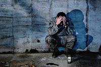 Airman crouches in anguish with head in hands. (U.S. Air Force photo illustration/Airman 1st Class Corey Hook)