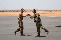 U.S. Air Force Staff Sgt. Dustin Cote bumps fists with Staff Sgt. John Bouscher after the first C-130 landing at Nigerien Air Base 201, Agadez, Niger, Aug. 3, 2019. (U.S. Air Force/Staff Sgt. Devin Boyer)