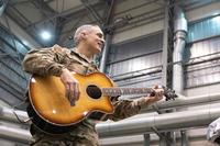 Ramon &quot;CZ&quot; Colon-Lopez plays guitar at a USO variety-show.