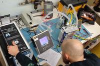 A biomedical equipment specialist conducts depot-level maintenance on a ventilator.