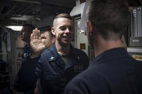 Lt. Jamie Jordan, right, administers the oath of reenlistment to Fire Controlman 2nd Class Joseph Johnson