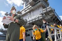 Sailors assigned to the USS Theodore Roosevelt depart the ship to move to off-ship berthing in Guam.