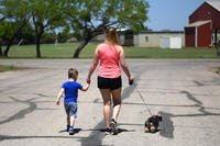 mother and son walking dog